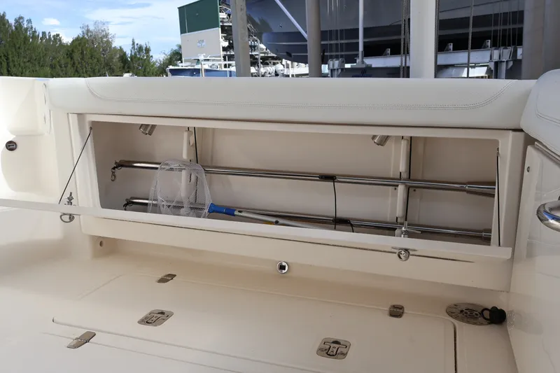 Slide: The Image of 2023 Pursuit OS 385 Offshore boat storage compartment with fishing gear and net. - 21