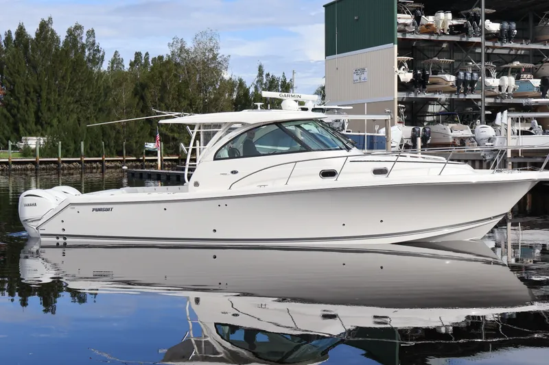 The Image of 2023 Pursuit OS 385 Offshore boat docked near marina with reflections on water. - 0