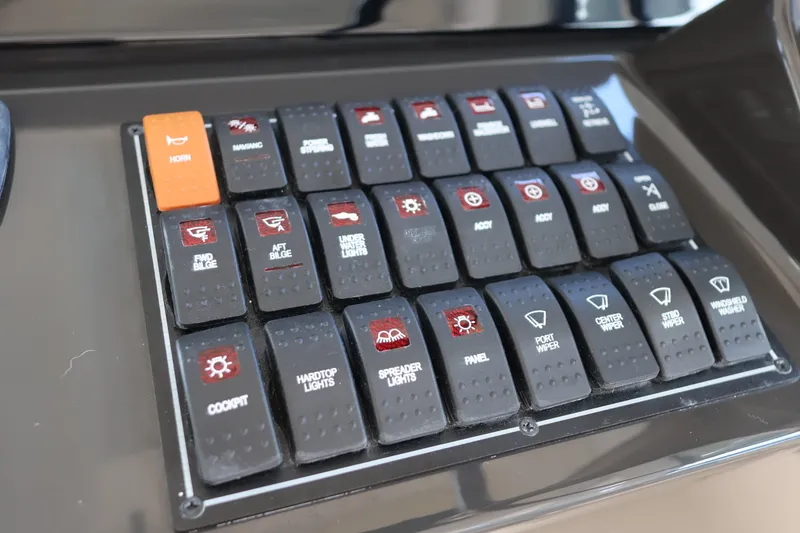 Slide: The Image of Control panel of 2023 Pursuit OS 385 Offshore boat with labeled switches. - 29