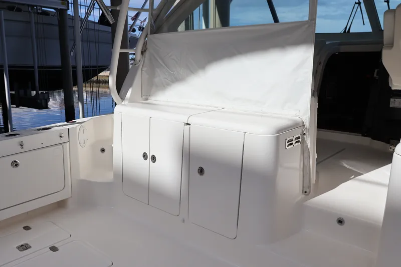 Slide: The Image of 2023 Pursuit OS 385 Offshore boat interior with storage compartments and seating area. - 22