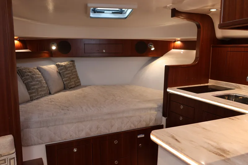 Slide: The Image of Luxurious cabin interior of 2023 Pursuit OS 385 Offshore boat with bed and kitchenette. - 44