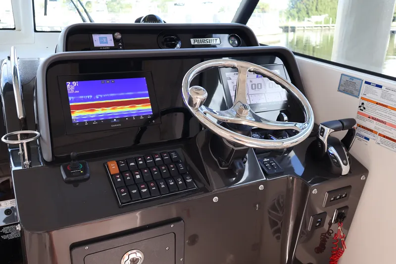 Slide: The Image of Control panel of 2023 Pursuit OS 385 Offshore boat with steering wheel and navigation display. - 27