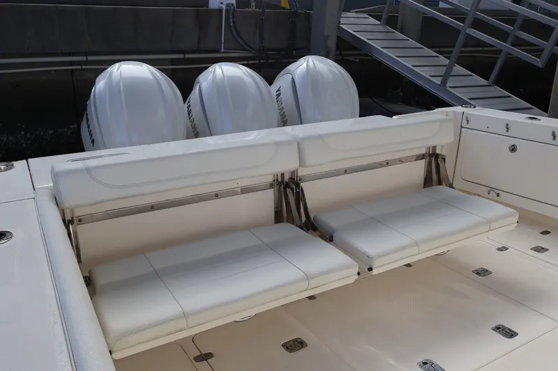Slide: The Image of 2023 Pursuit OS 385 Offshore boat with triple outboard engines and foldable seating. - 13