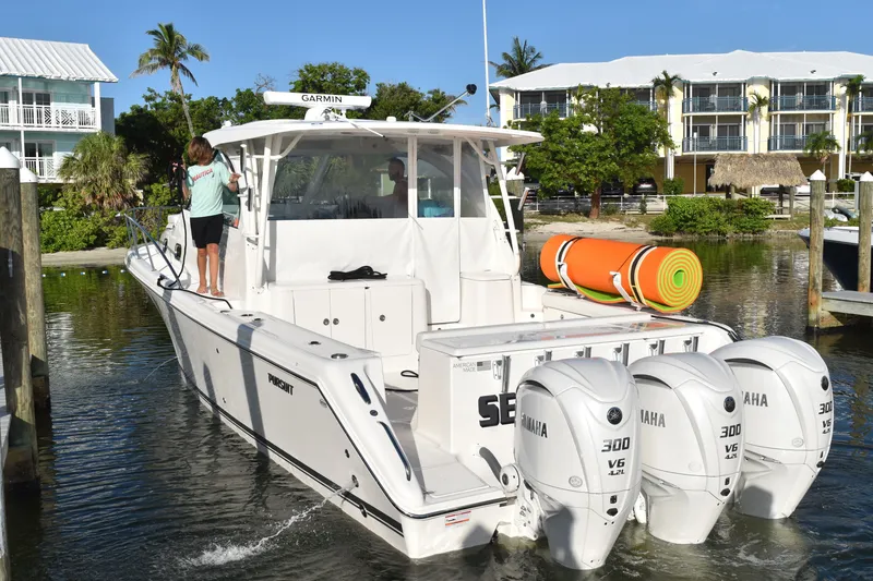Slide: The Image of 2023 Pursuit OS 385 Offshore boat docked with triple Yamaha engines. - 2