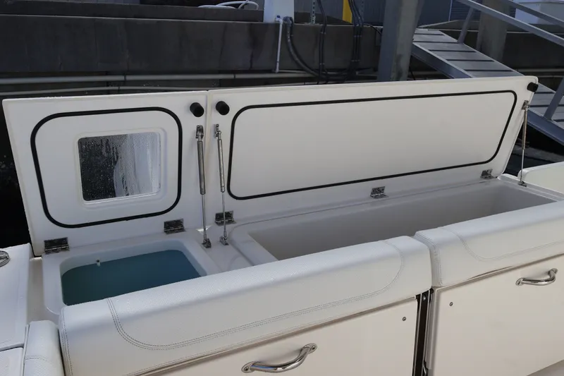 Slide: The Image of 2023 Pursuit OS 385 Offshore boat storage compartments open, showcasing interior features. - 16