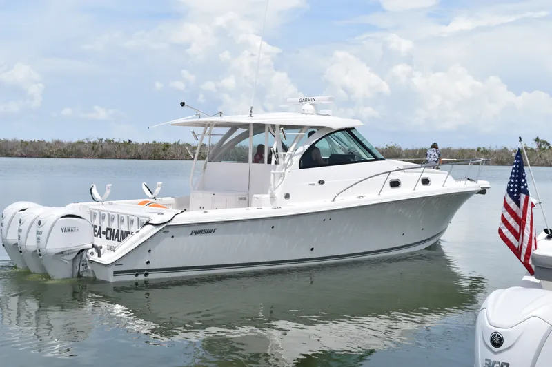 The Image of 2023 Pursuit OS 385 Offshore boat on calm water with American flag. - 0