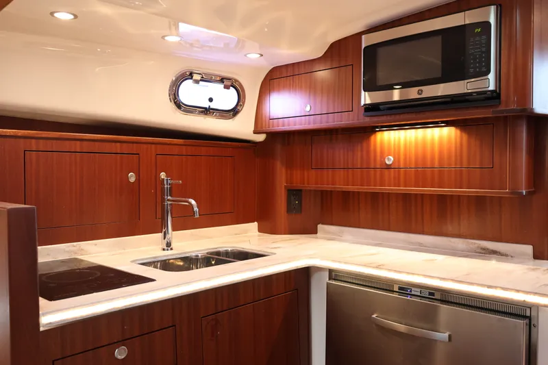 Slide: The Image of 2023 Pursuit OS 385 Offshore yacht kitchen with wood cabinetry and modern appliances. - 38
