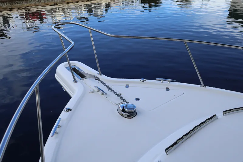 Slide: The Image of Bow of 2023 Pursuit OS 385 Offshore boat with anchor chain and calm water. - 53