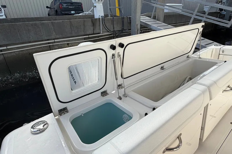 Slide: The Image of 2023 Pursuit OS 385 Offshore boat with open storage compartments at dock. - 20