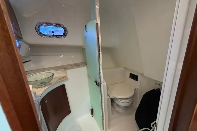 Slide: The Image of 2023 Pursuit OS 385 Offshore boat bathroom with modern fixtures and porthole window. - 49