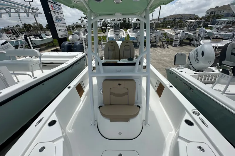 Slide: The Image of 2026 Sea Pro 230 Bay boat interior with seating and console, displayed at a marina. - 8