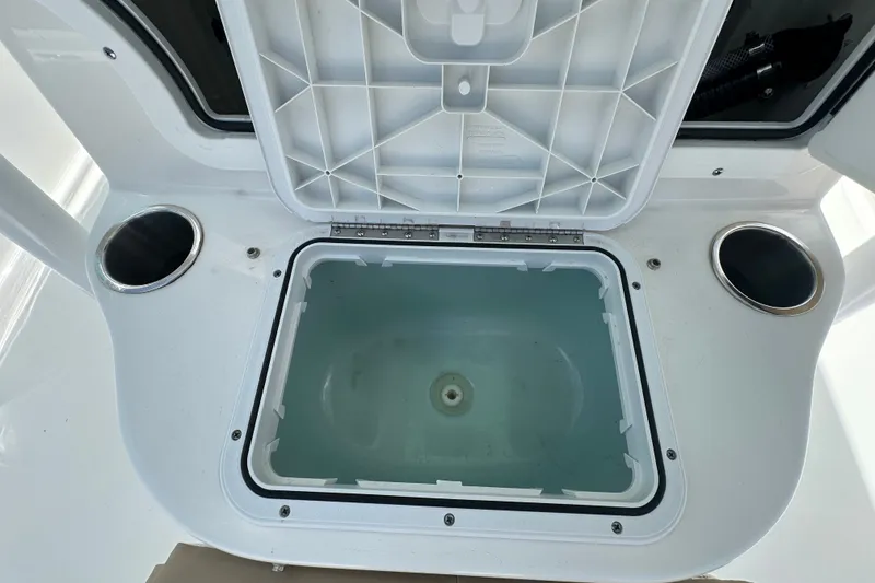 Slide: The Image of Open storage compartment on 2026 Sea Pro 230 Bay boat, featuring cup holders. - 13