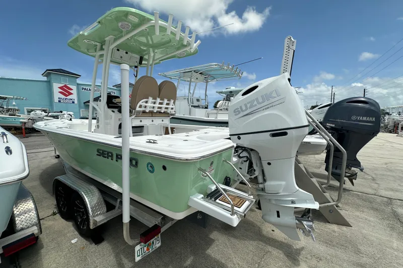 Slide: The Image of 2026 Sea Pro 230 Bay boat with Suzuki outboard motor at a marina. - 2