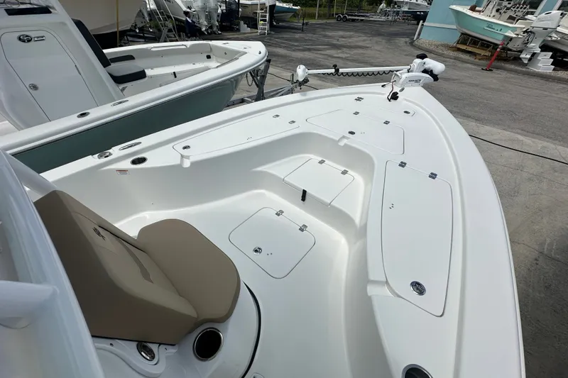 Slide: The Image of 2026 Sea Pro 230 Bay boat with spacious deck and seating, docked outdoors. - 7