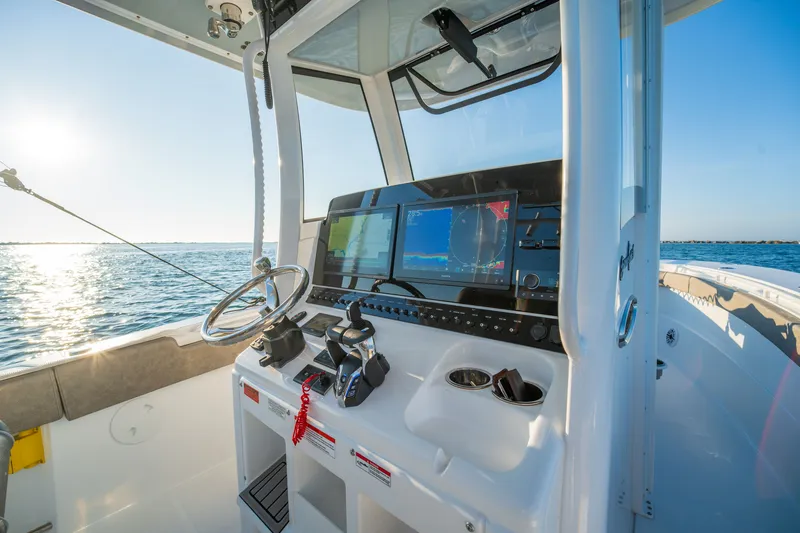 Slide: The Image of 2026 Sea Hunt Gamefish 30CB boat cockpit with advanced navigation system on open water. - 16