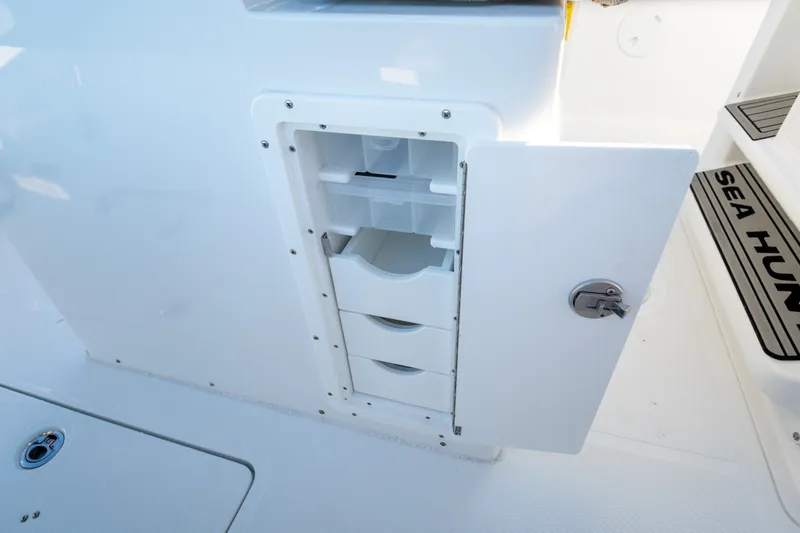 Slide: The Image of 2026 Sea Hunt Gamefish 30CB boat storage compartment with open door and drawers. - 24