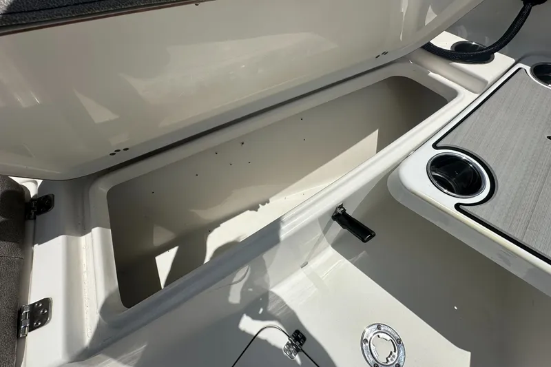 Slide: The Image of 2024 Sea Pro 262 Center Console storage compartment with cup holders and latch. - 11