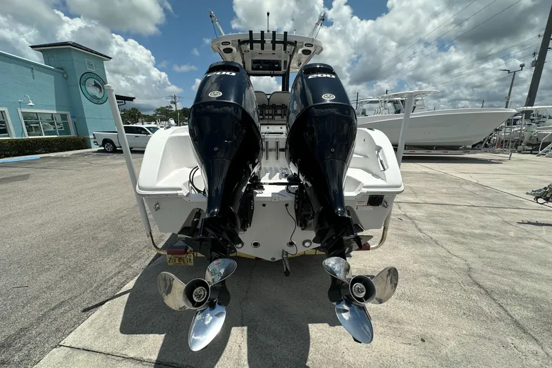 Slide: The Image of 2024 Sea Pro 262 Center Console boat with dual outboard engines, parked outdoors. - 4
