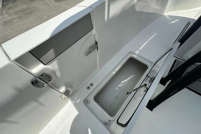 Slide: The Image of 2024 Sea Pro 262 Center Console boat storage compartment with open hatch and sleek design. - 17