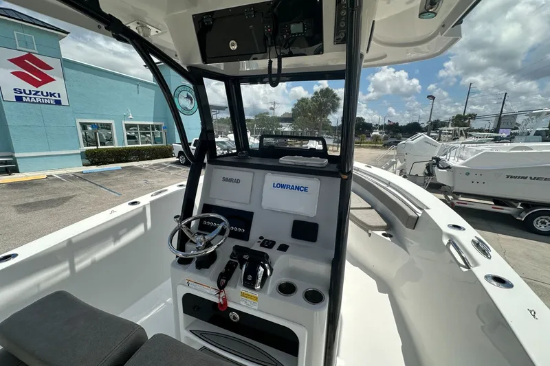 Slide: The Image of 2024 Sea Pro 262 Center Console boat interior with navigation equipment, parked near Suzuki Marine. - 6
