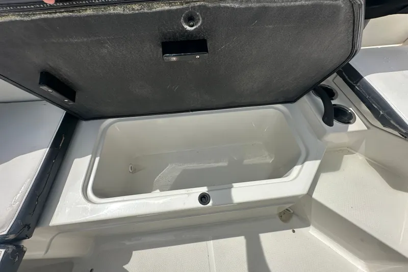 Slide: The Image of Open storage compartment on 2015 Sea Ray 21 SPX OB boat, featuring cup holders. - 11