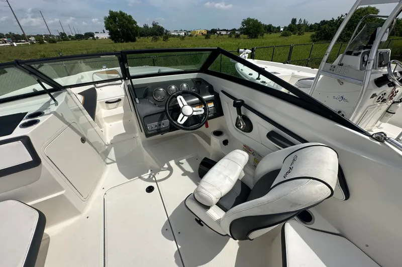 Slide: The Image of Interior view of 2015 Sea Ray 21 SPX OB boat, featuring steering wheel and seating. - 6