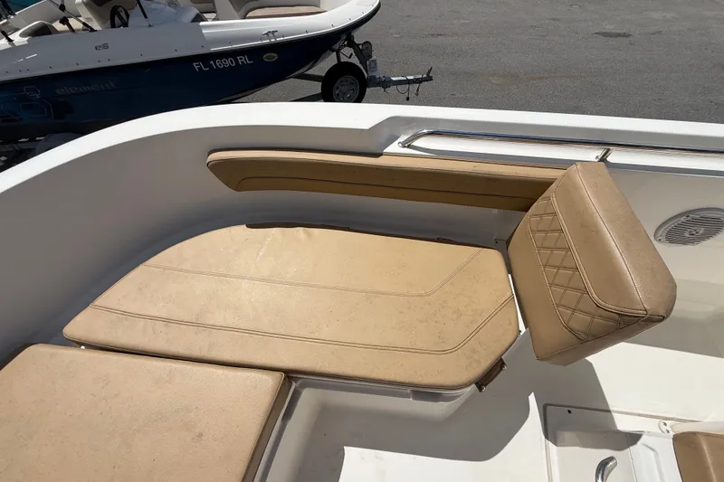 Slide: The Image of 2024 Bayliner Trophy T22CC boat with tan cushioned seating and sleek design. - 39