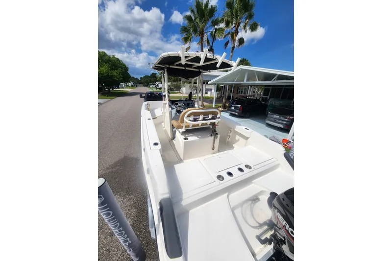 Slide: The Image of 2024 Bayliner Trophy T22CC boat on a sunny street with palm trees. - 5
