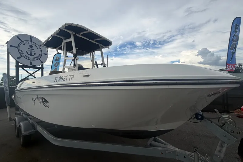 The Image of 2024 Bayliner Trophy T22CC boat on trailer, displayed outdoors under cloudy sky. - 0
