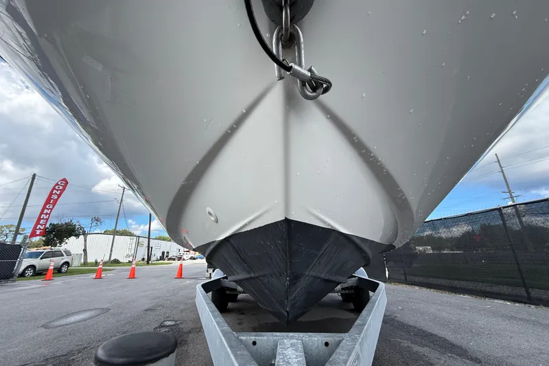 Slide: The Image of 2024 Bayliner Trophy T22CC boat on trailer, viewed from below, with overcast sky. - 14