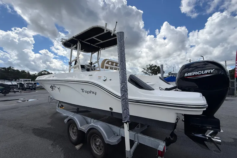 Slide: The Image of 2024 Bayliner Trophy T22CC boat with Mercury engine on trailer under cloudy sky. - 9