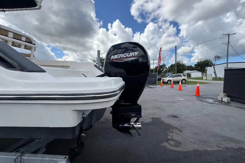 Slide: The Image of 2024 Bayliner Trophy T22CC with Mercury outboard motor, parked outdoors under cloudy sky. - 8