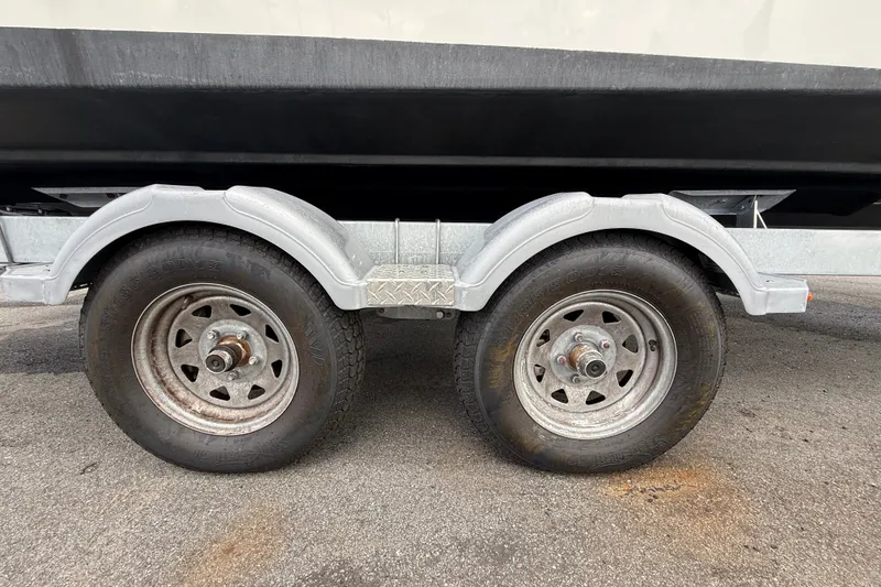 Slide: The Image of Trailer wheels for 2024 Bayliner Trophy T22CC boat on pavement. - 70
