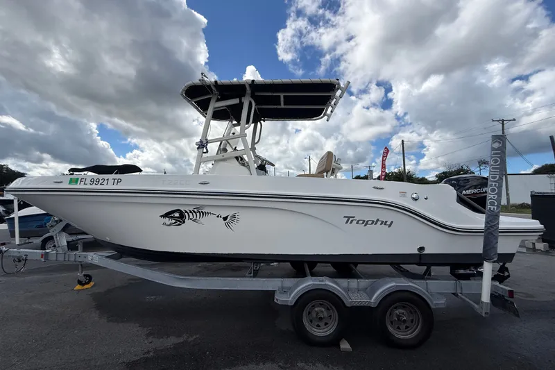 Slide: The Image of 2024 Bayliner Trophy T22CC boat on trailer under cloudy sky. - 10