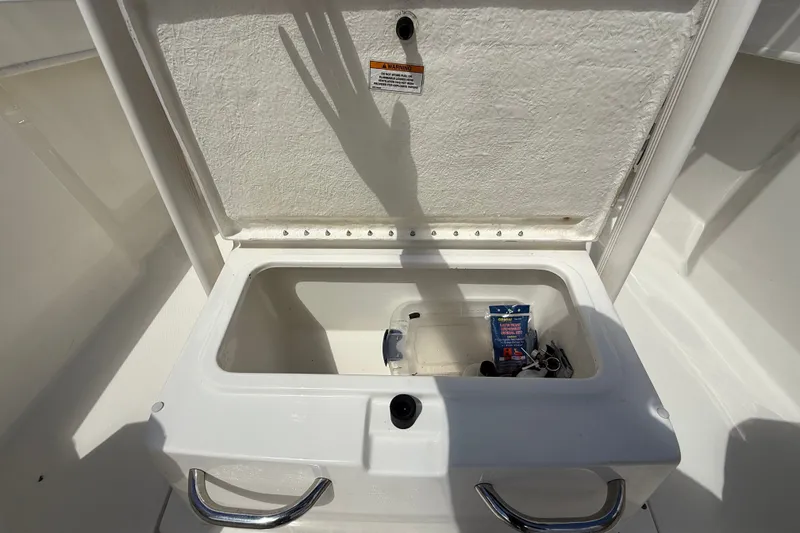 Slide: The Image of Open storage compartment on 2024 Bayliner Trophy T22CC boat, featuring stainless steel handles. - 47