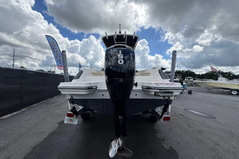 Slide: The Image of 2024 Bayliner Trophy T22CC boat with 150 HP engine, displayed outdoors under cloudy sky. - 5