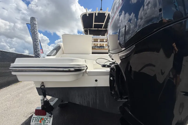 Slide: The Image of 2024 Bayliner Trophy T22CC boat rear view with outboard motor and trailer. - 7