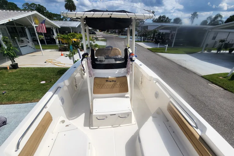 Slide: The Image of 2024 Bayliner Trophy T22CC boat with spacious deck and seating, parked in a residential area. - 3