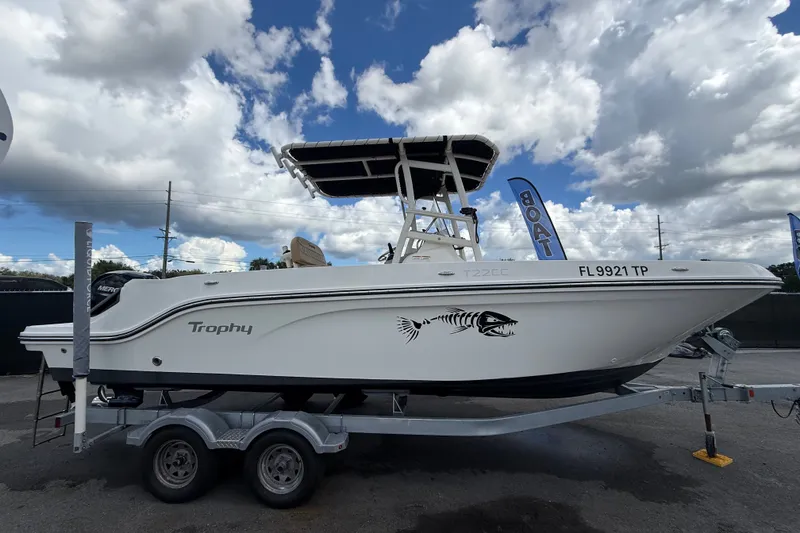 Slide: The Image of 2024 Bayliner Trophy T22CC boat on trailer under cloudy sky. - 1