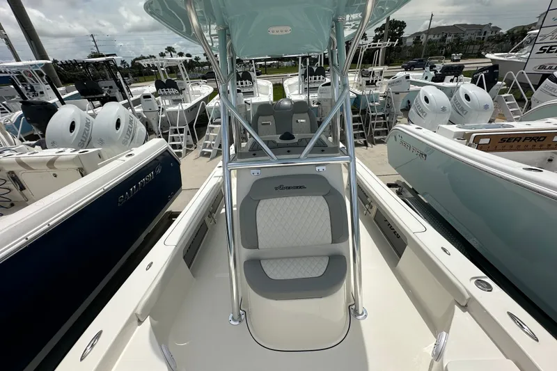 Slide: The Image of 2027 Avenger AV26 boat interior with seating, surrounded by other boats at a marina. - 14