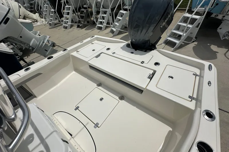 Slide: The Image of 2027 Avenger AV26 boat deck with Yamaha outboard motor, featuring storage compartments and seating. - 18