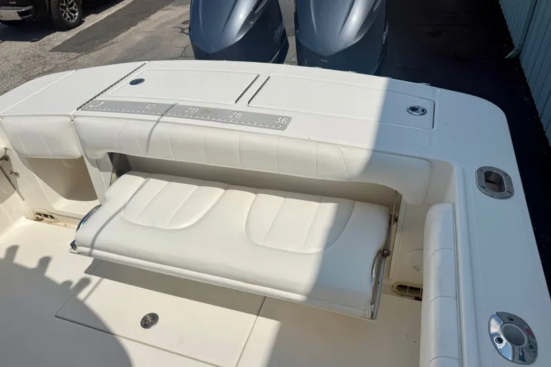 Slide: The Image of 2014 Regulator 28 Forward Seating boat with white cushioned seats and measuring ruler. - 14