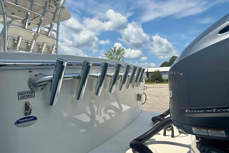 Slide: The Image of 2014 Regulator 28 Forward Seating boat with rod holders and Yamaha outboard motor. - 16