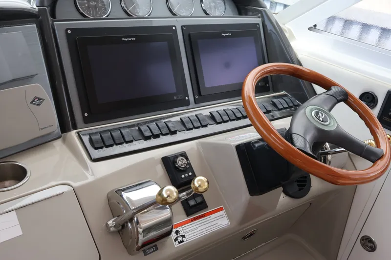 Slide: The Image of 2006 Sea Ray 40 Motor Yacht helm with dual Raymarine displays and wooden steering wheel. - 31