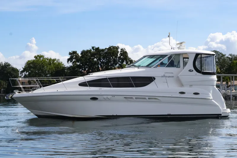 Slide: The Image of 2006 Sea Ray 40 Motor Yacht on calm water, surrounded by trees. - 7