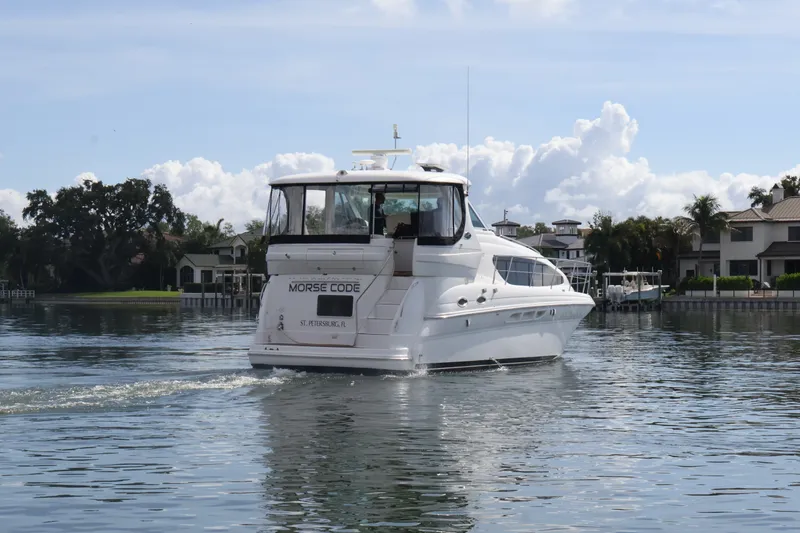 Slide: The Image of 2006 Sea Ray 40 Motor Yacht cruising on calm waters near waterfront homes. - 13
