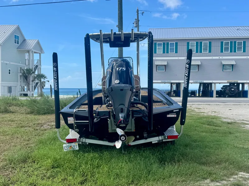 Slide: The Image of A 2026 Xpress H22 boat on a trailer in front of a beach house. - 1