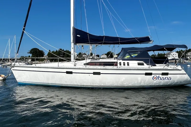 The Image of Hunter Legend 43 sailboat from 1992 named "Ohana" on calm water under clear blue sky. - 0