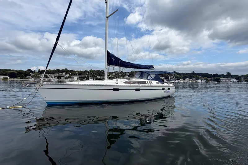 Slide: The Image of Sailboat Hunter Legend 43, 1992 model, anchored on calm water under cloudy sky. - 5