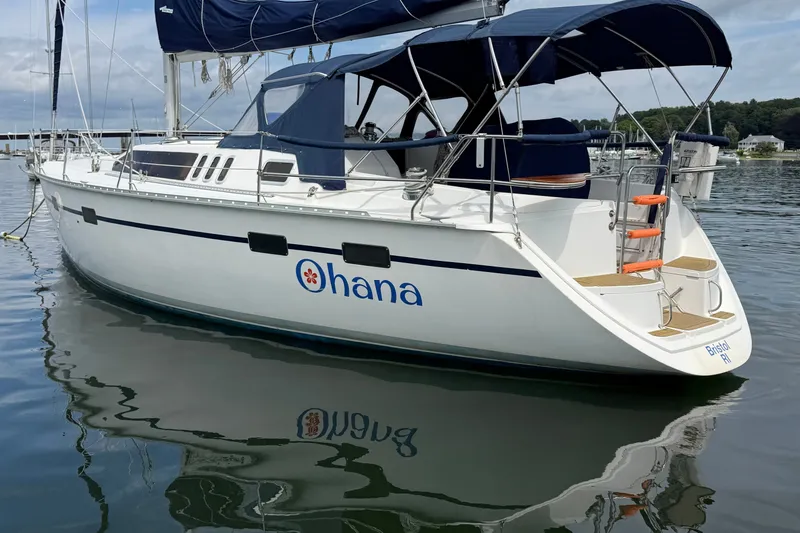 Slide: The Image of Hunter Legend 43 sailboat from 1992, named "Ohana," docked on calm water. - 3
